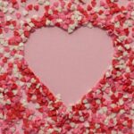 Sentiment - Paper hearts scattered on pink background