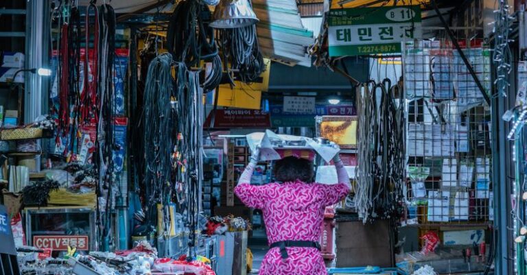 Stocks - Woman Walking on Pathway Between Stores