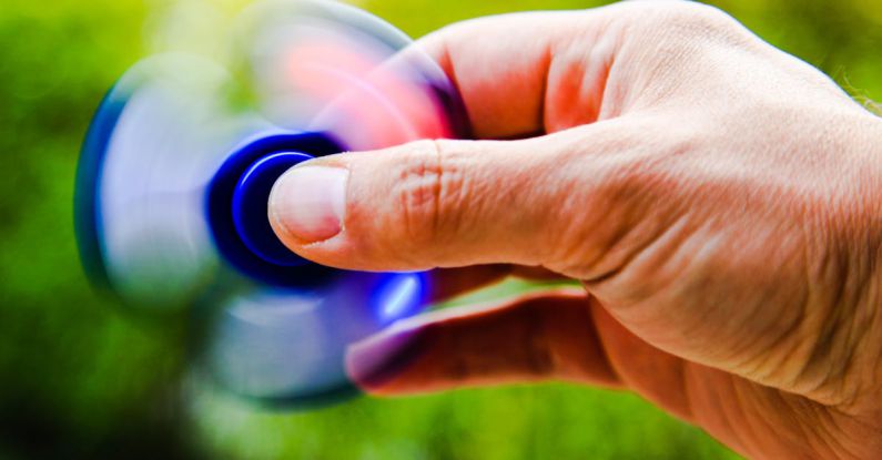 Trends - Person Playing Blue Hand Spinner