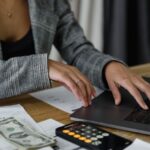 Profitability - A Woman in Plaid Blazer Using Her Laptop